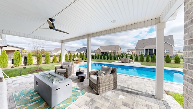 view of swimming pool with an outdoor living space with a fire pit, ceiling fan, and a patio area