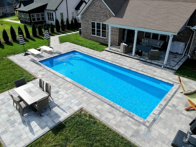 view of swimming pool featuring outdoor lounge area, a yard, and a patio area