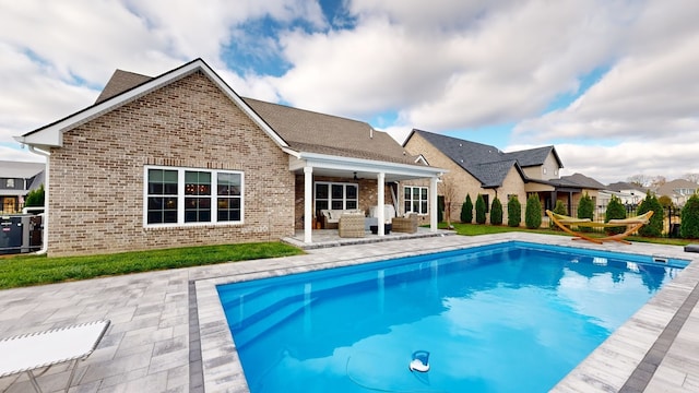 rear view of property featuring ceiling fan, outdoor lounge area, central AC unit, and a patio area