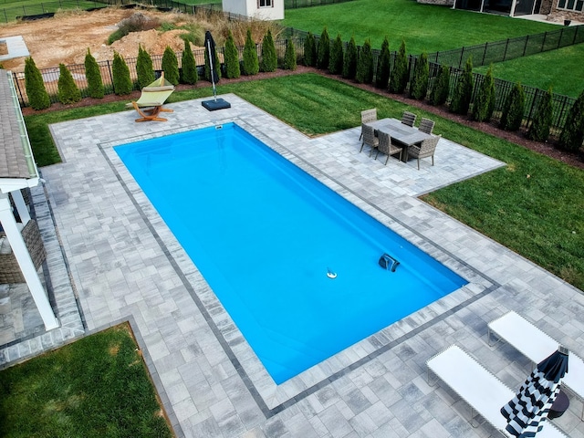 view of pool featuring a lawn and a patio