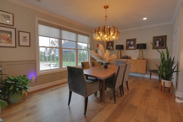 dining area with an inviting chandelier, crown molding, and light wood-type flooring