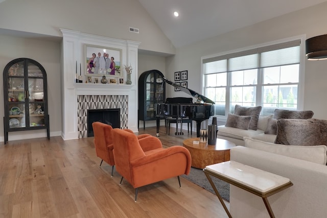 living room featuring high vaulted ceiling and light wood-type flooring