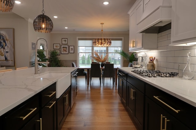 kitchen with white cabinetry, stainless steel appliances, custom exhaust hood, and pendant lighting