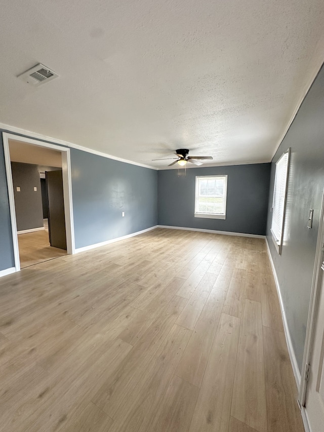 empty room with ceiling fan, light hardwood / wood-style flooring, and a textured ceiling