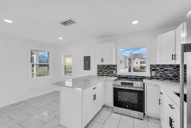 kitchen featuring kitchen peninsula, white cabinetry, electric panel, and stainless steel range oven