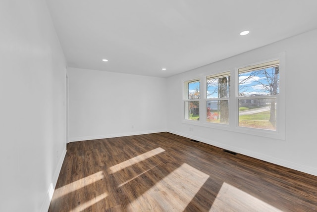 unfurnished room with dark wood-type flooring