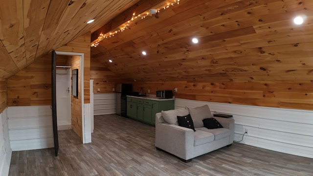 unfurnished room with sink, wooden walls, vaulted ceiling, hardwood / wood-style flooring, and wood ceiling