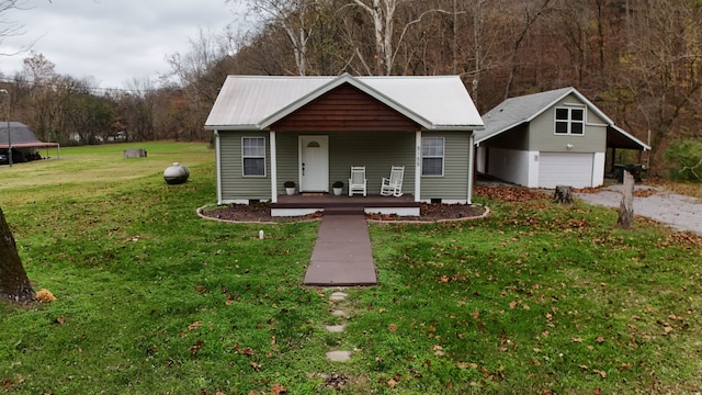 view of front of home featuring a front yard, a porch, a garage, and an outdoor structure