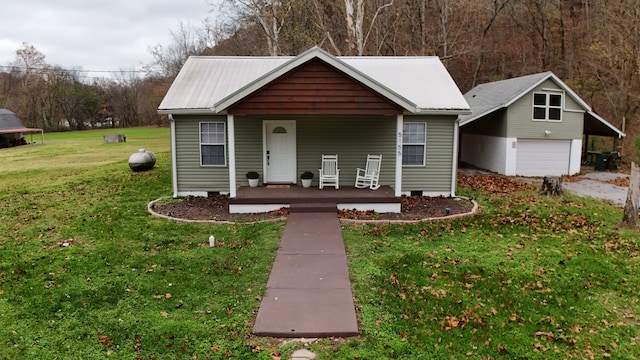 view of front of house featuring a garage, covered porch, and a front yard