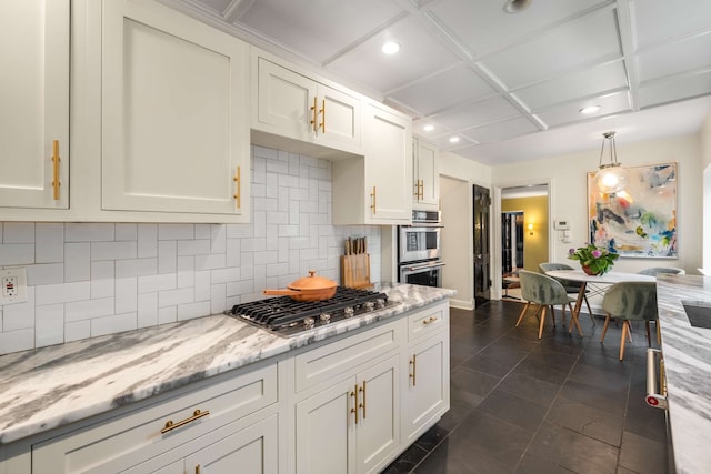 kitchen with white cabinetry, light stone countertops, stainless steel appliances, tasteful backsplash, and decorative light fixtures