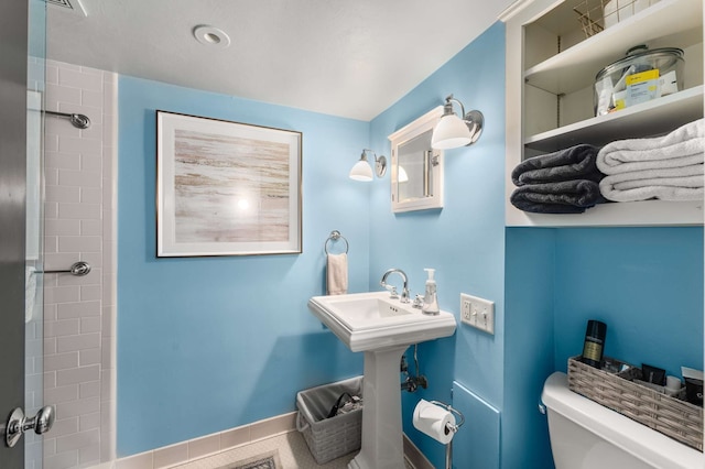 bathroom featuring a shower and toilet