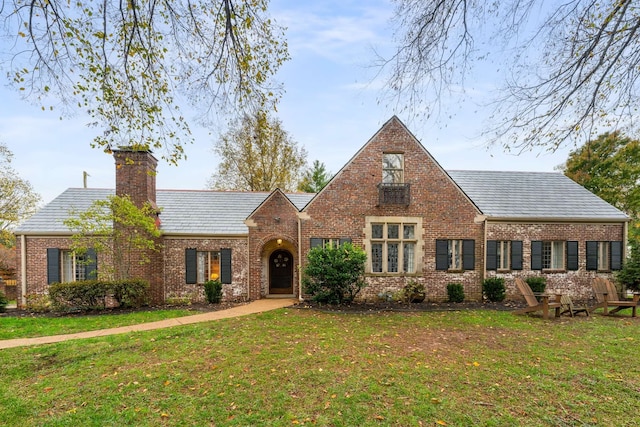 english style home with a front lawn