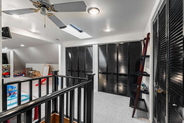 hall featuring a skylight and carpet floors