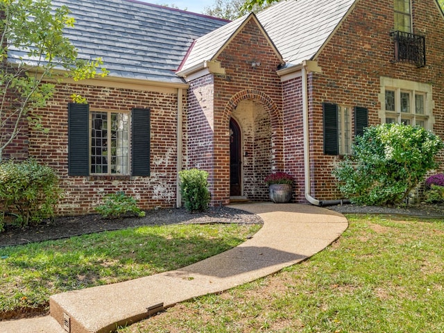 property entrance with a lawn