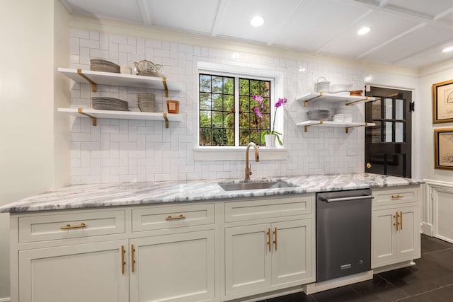 kitchen with dishwasher, backsplash, light stone counters, and sink