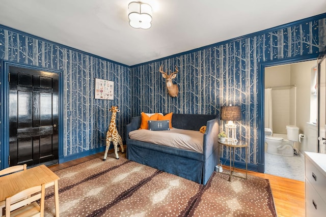 bedroom featuring ensuite bathroom and wood-type flooring