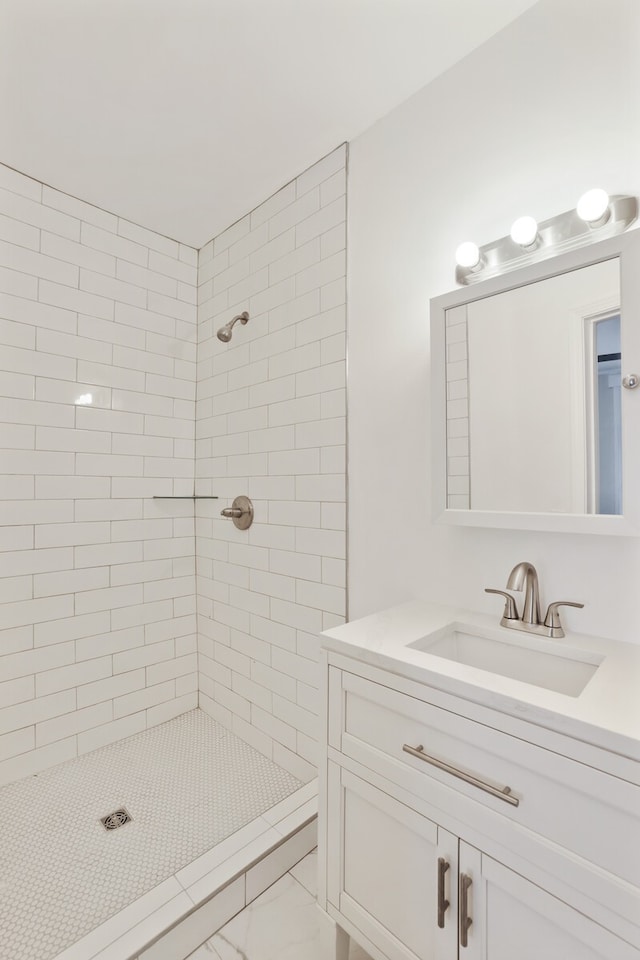 bathroom with vanity and tiled shower