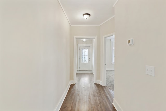 hallway with ornamental molding and light wood-type flooring