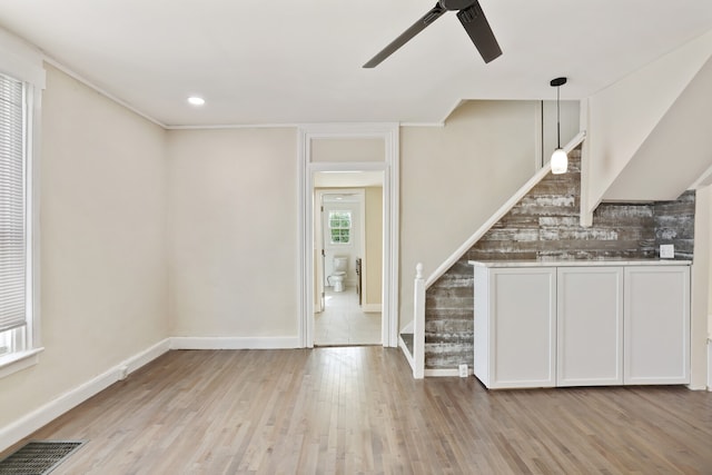 kitchen with ceiling fan, hanging light fixtures, tasteful backsplash, light hardwood / wood-style floors, and white cabinets