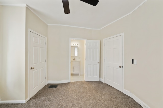 unfurnished bedroom featuring carpet flooring, ensuite bathroom, ceiling fan, and ornamental molding