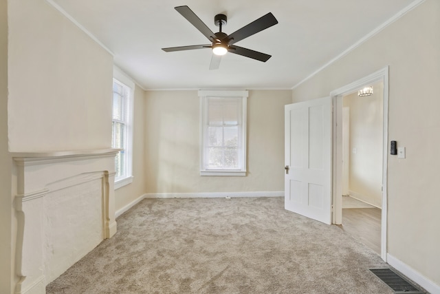 carpeted empty room with ceiling fan and ornamental molding