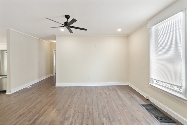 spare room featuring crown molding, ceiling fan, and light wood-type flooring