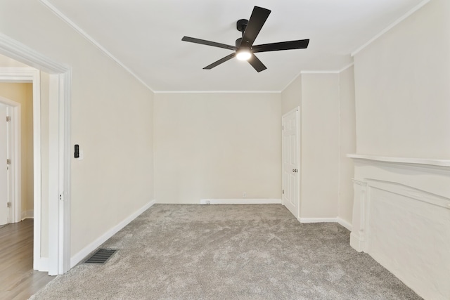 carpeted spare room featuring ceiling fan and crown molding