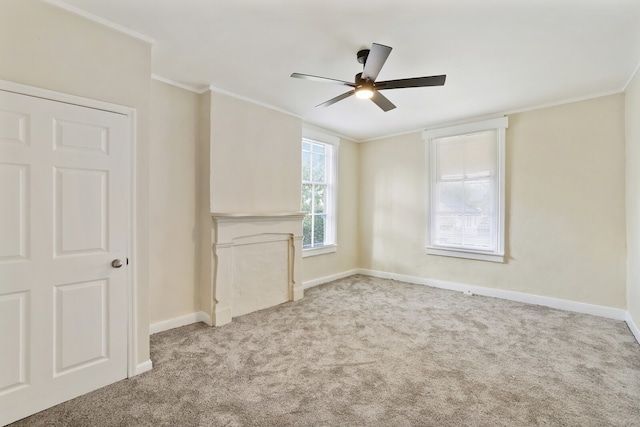 unfurnished living room with ceiling fan, crown molding, and light carpet