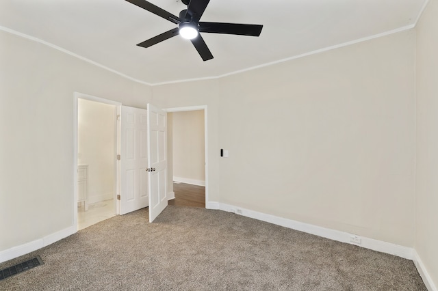 unfurnished bedroom featuring ceiling fan, crown molding, carpet floors, and ensuite bathroom