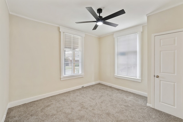 empty room with light colored carpet, ceiling fan, and ornamental molding