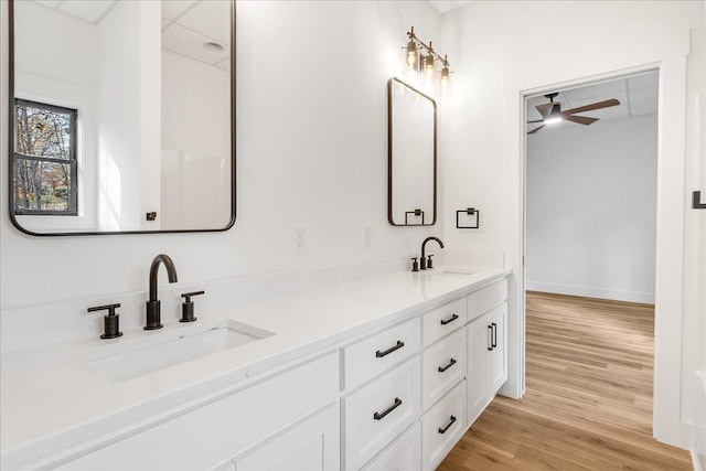 bathroom with wood-type flooring, vanity, and ceiling fan