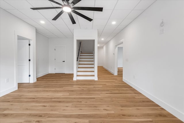 interior space featuring ceiling fan, a drop ceiling, and light wood-type flooring