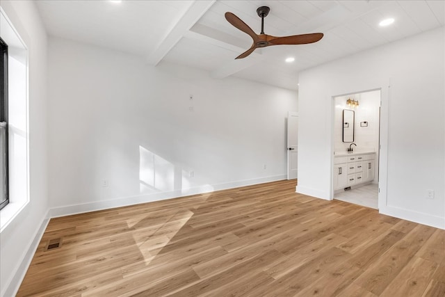 unfurnished bedroom featuring ensuite bath, ceiling fan, light hardwood / wood-style flooring, and beamed ceiling