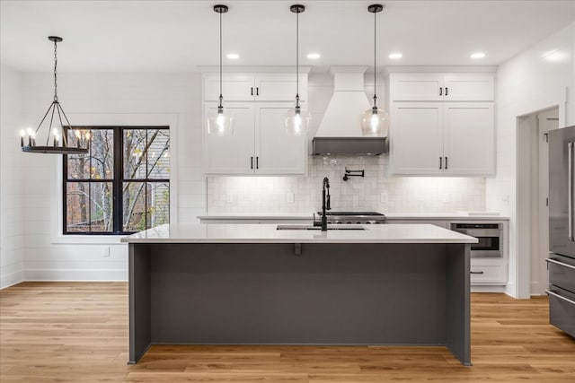 kitchen with light hardwood / wood-style flooring, oven, white cabinetry, and custom exhaust hood