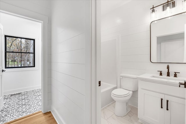 full bathroom featuring hardwood / wood-style floors, vanity, washtub / shower combination, wooden walls, and toilet