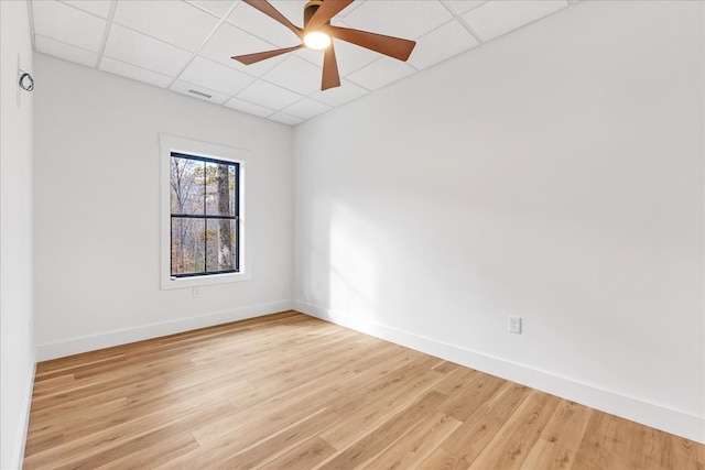 spare room featuring a paneled ceiling, ceiling fan, and light hardwood / wood-style floors