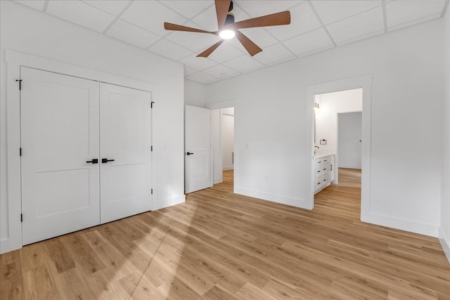 unfurnished bedroom with ceiling fan, a closet, and light hardwood / wood-style flooring