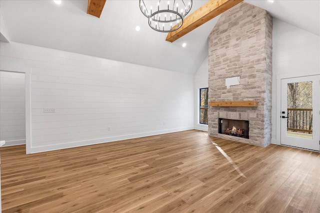 unfurnished living room featuring beamed ceiling, hardwood / wood-style floors, high vaulted ceiling, and a fireplace