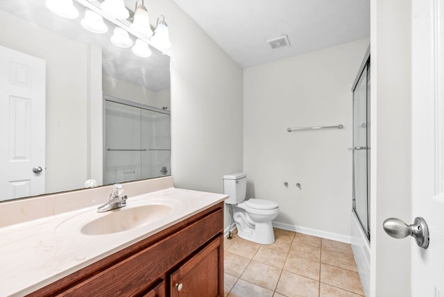 full bathroom with tile patterned floors, vanity, bath / shower combo with glass door, and toilet