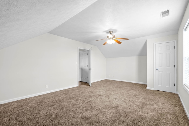 bonus room with carpet flooring, plenty of natural light, a textured ceiling, and vaulted ceiling