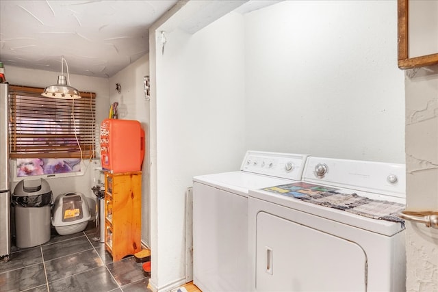 laundry room featuring separate washer and dryer and dark tile patterned flooring