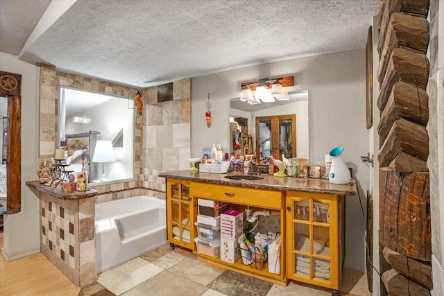 bathroom with a washtub, vanity, a textured ceiling, and hardwood / wood-style floors