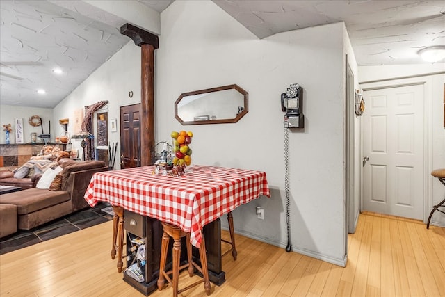 dining area with lofted ceiling and hardwood / wood-style flooring