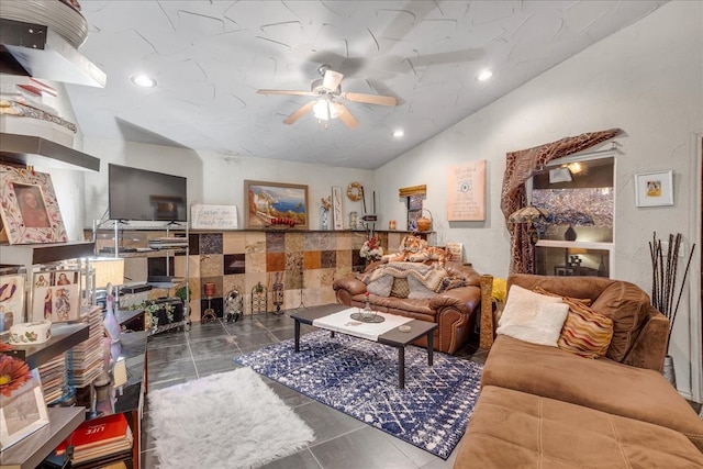 living room featuring ceiling fan, dark tile patterned floors, and vaulted ceiling