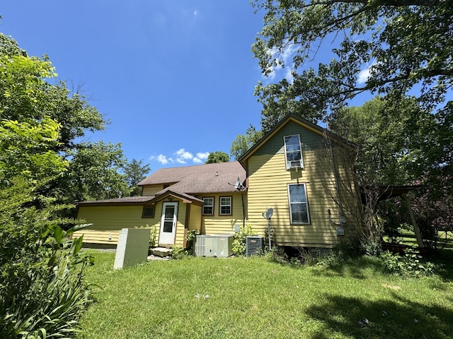 back of property with a lawn and central AC unit