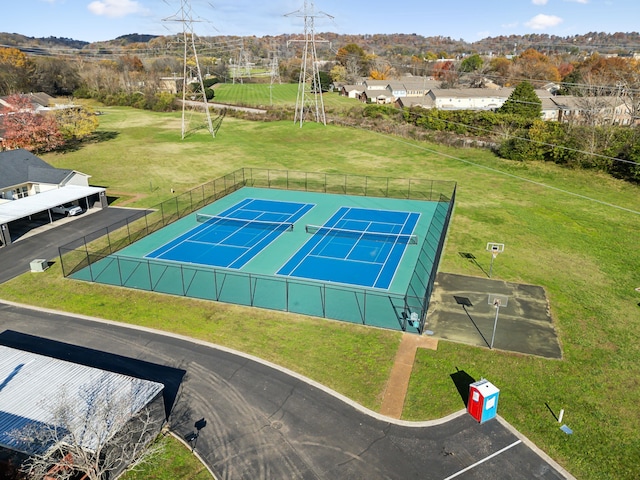 view of tennis court featuring a lawn