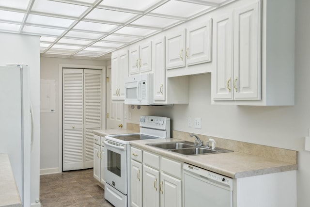 kitchen featuring white appliances, white cabinetry, and sink