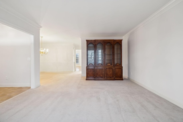 empty room featuring light carpet, ornamental molding, and a notable chandelier