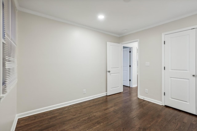 unfurnished bedroom with crown molding, dark wood-type flooring, and a closet