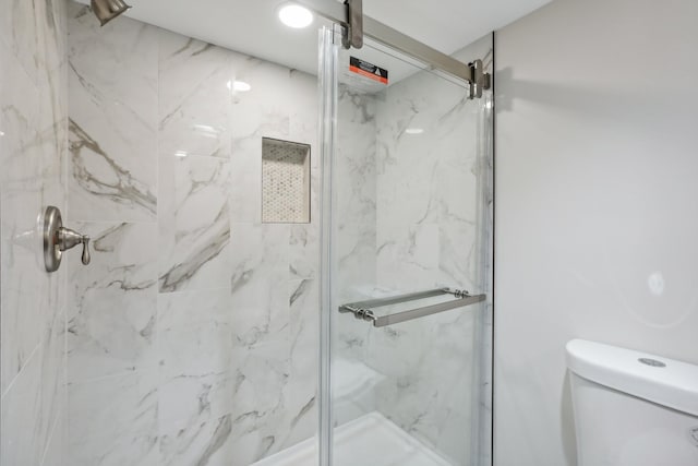 bathroom featuring an enclosed shower and toilet